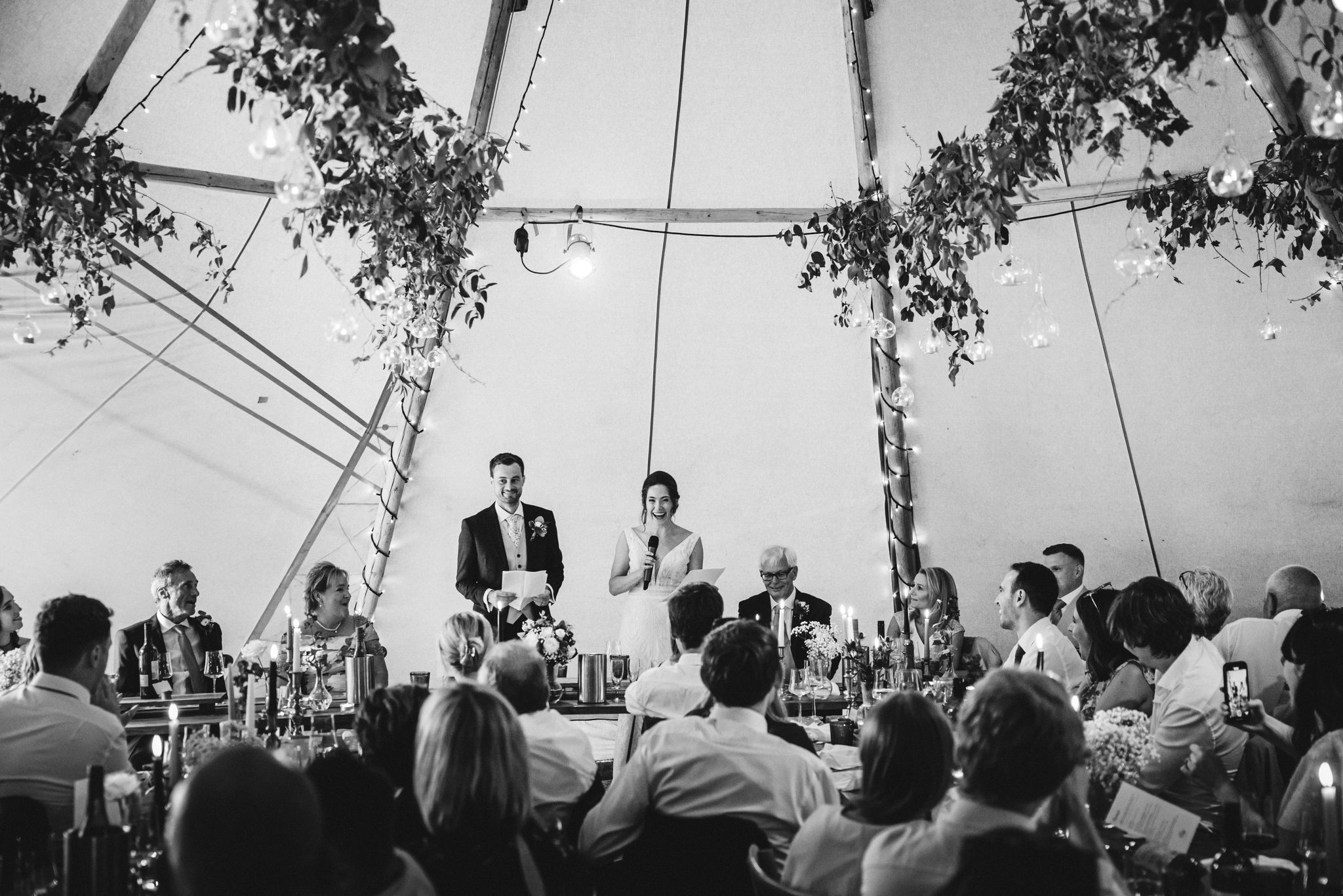 Wedding couple giving speeches during a relaxed reception in a decorated marquee